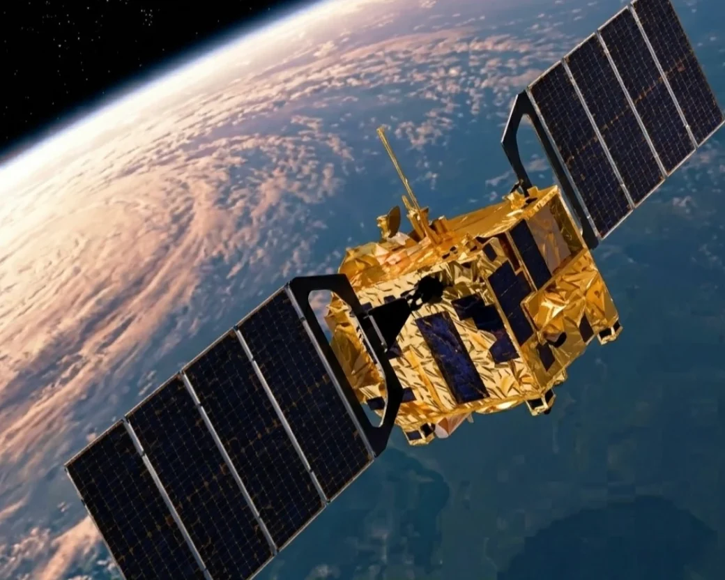 A gold-foil satellite with solar panels orbiting above Earth, the kind of system superconducting materials could power